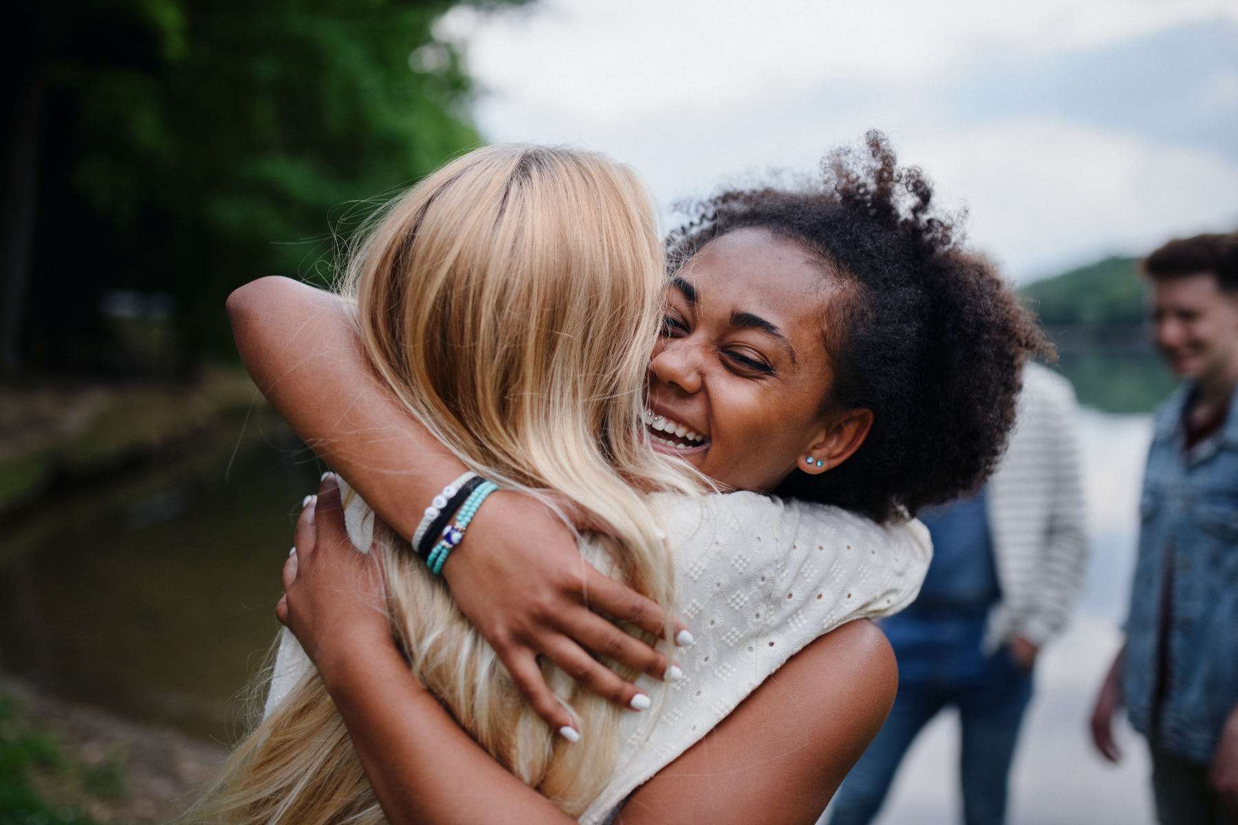 women-hugging-outside_519314189