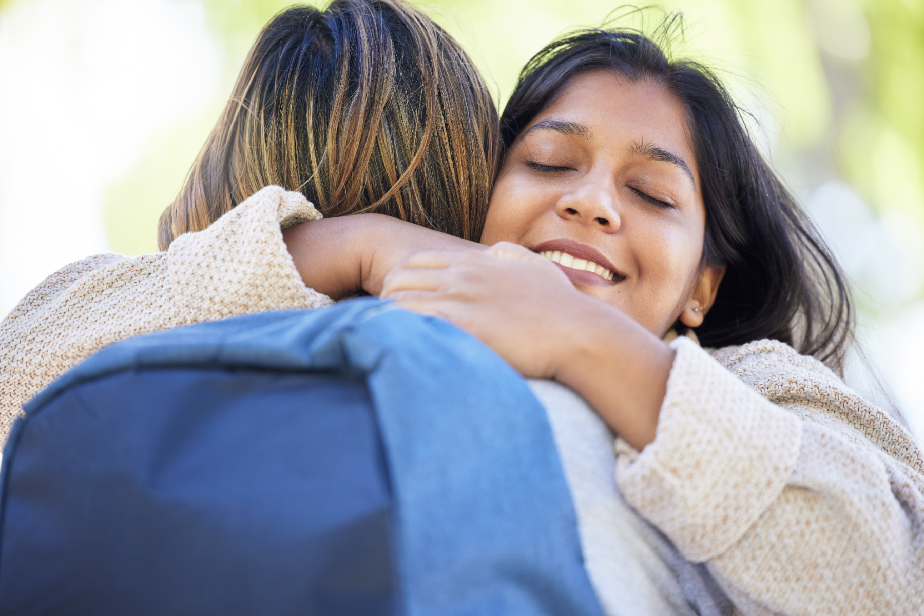 women-hugging-outside_576547474